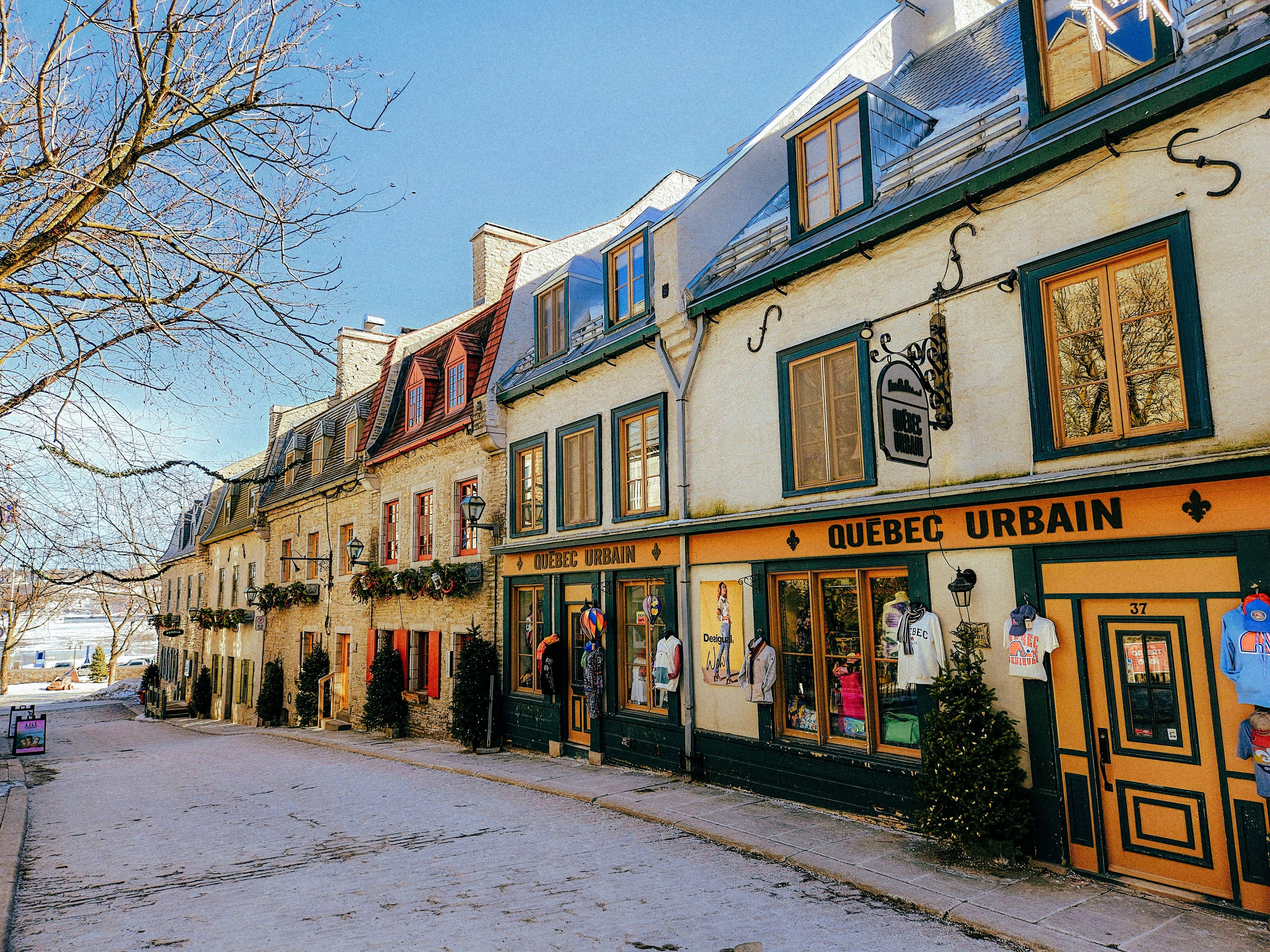 A row of colorful buildings with shops on a snowy street in Quebec City