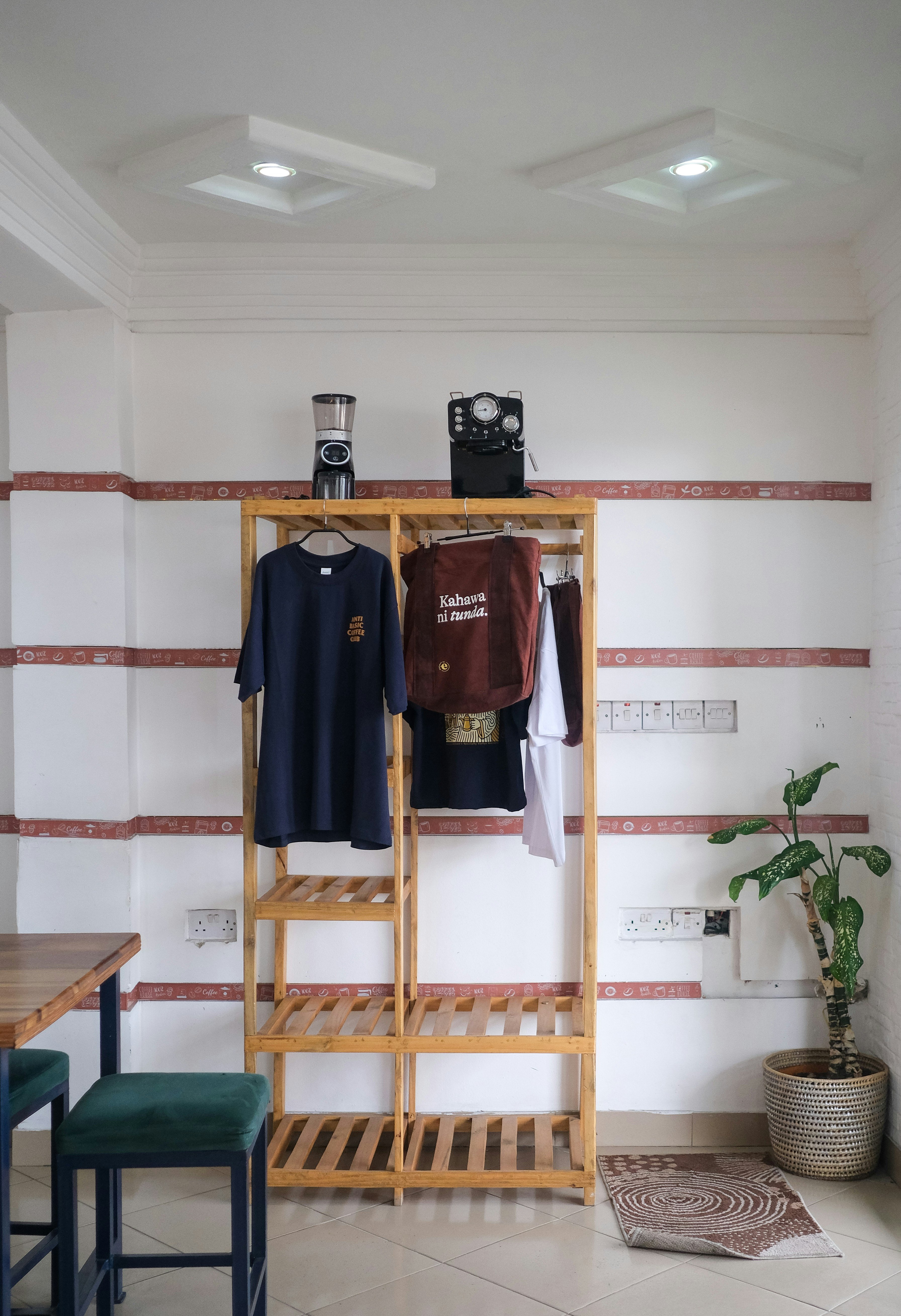 A wooden shelf with clothes and a plant