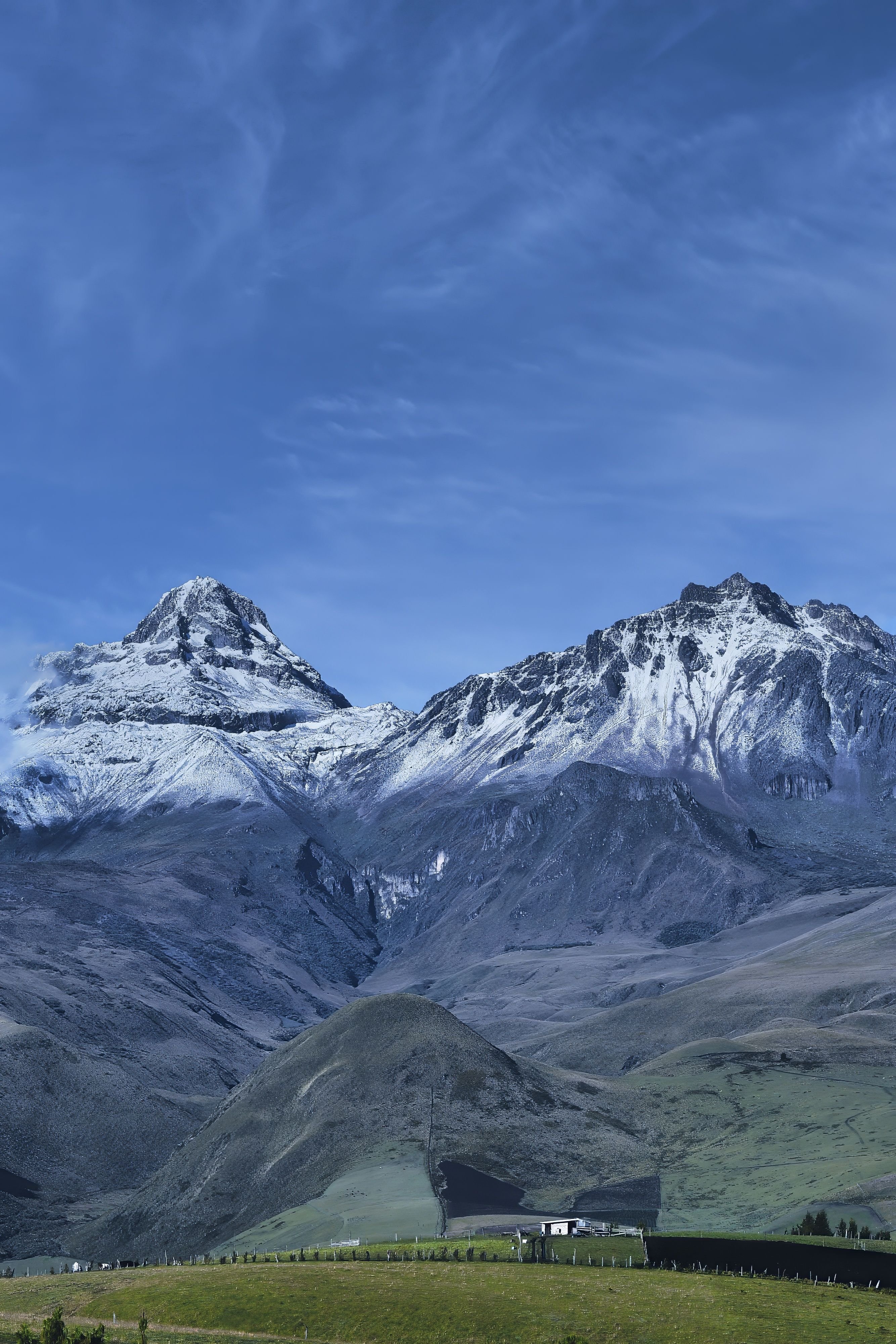 Snow-capped mountains with a clear blue sky and green valley below