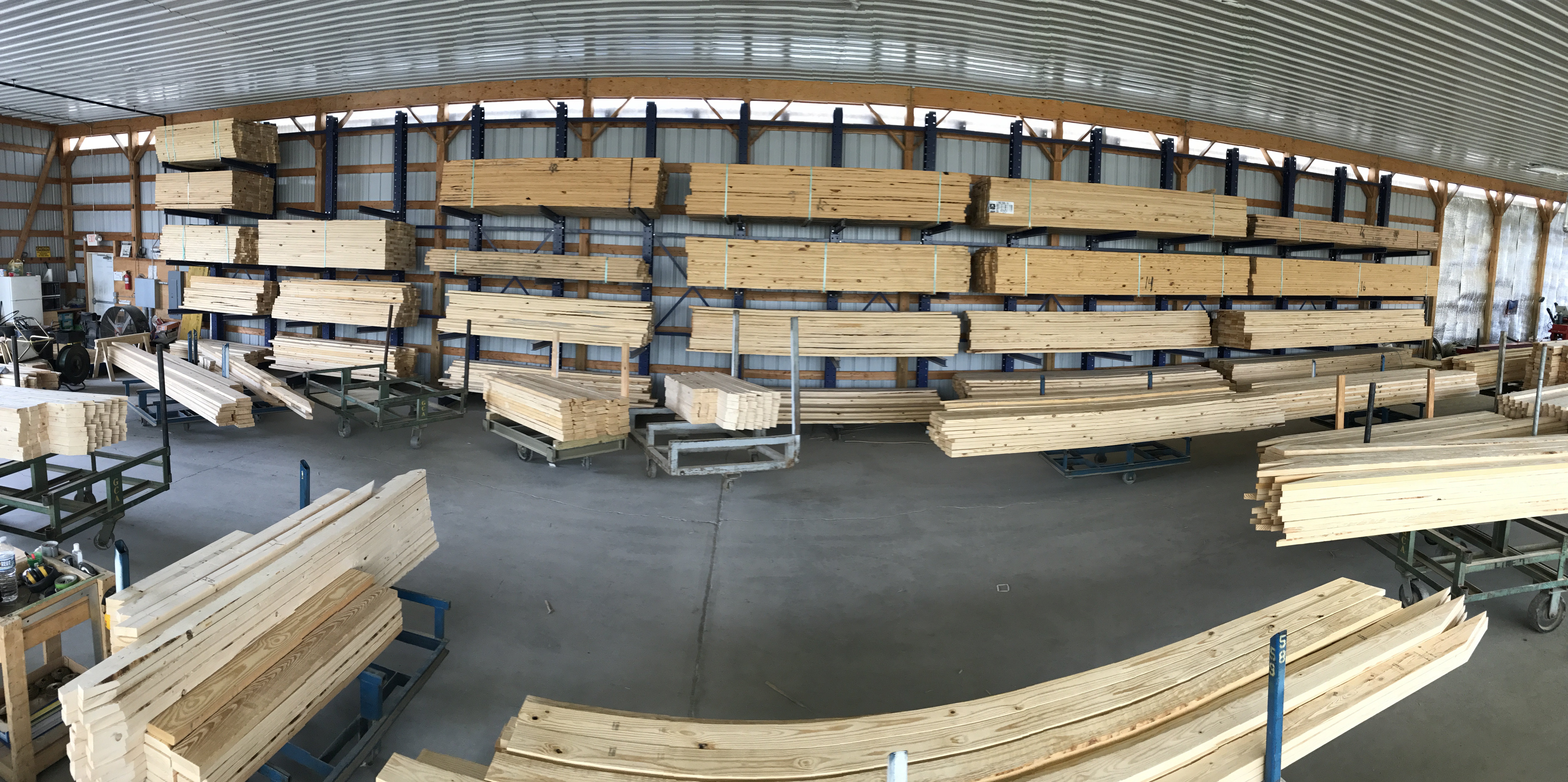A warehouse filled with wooden planks and lumber on metal racks