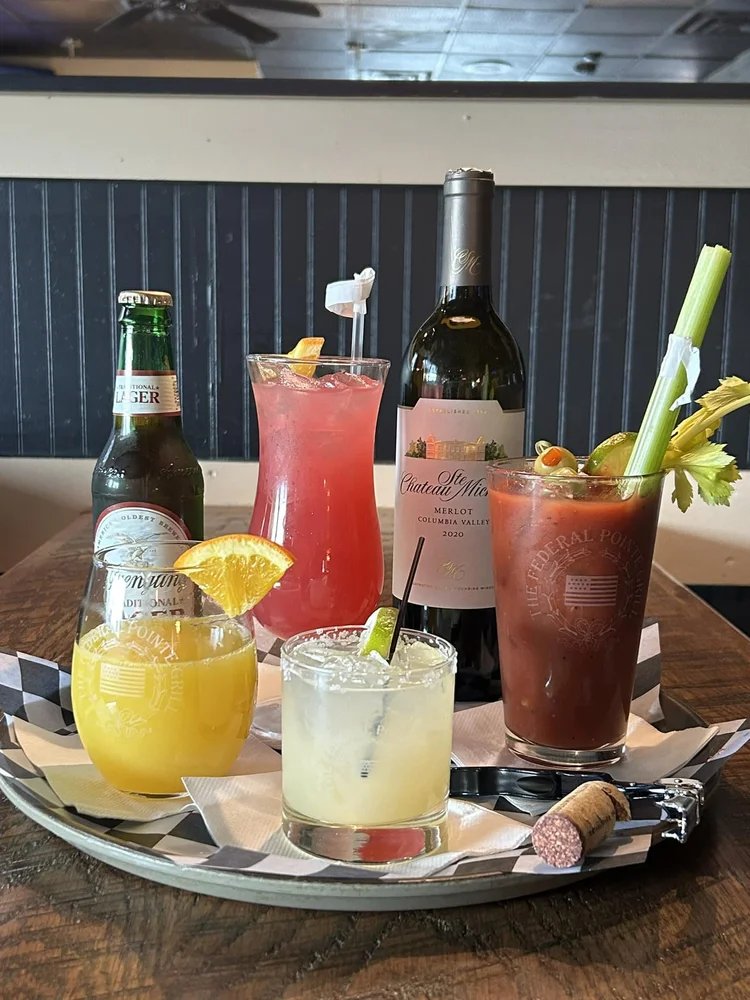 A table with various cocktails and drinks, including a beer bottle and wine bottle.