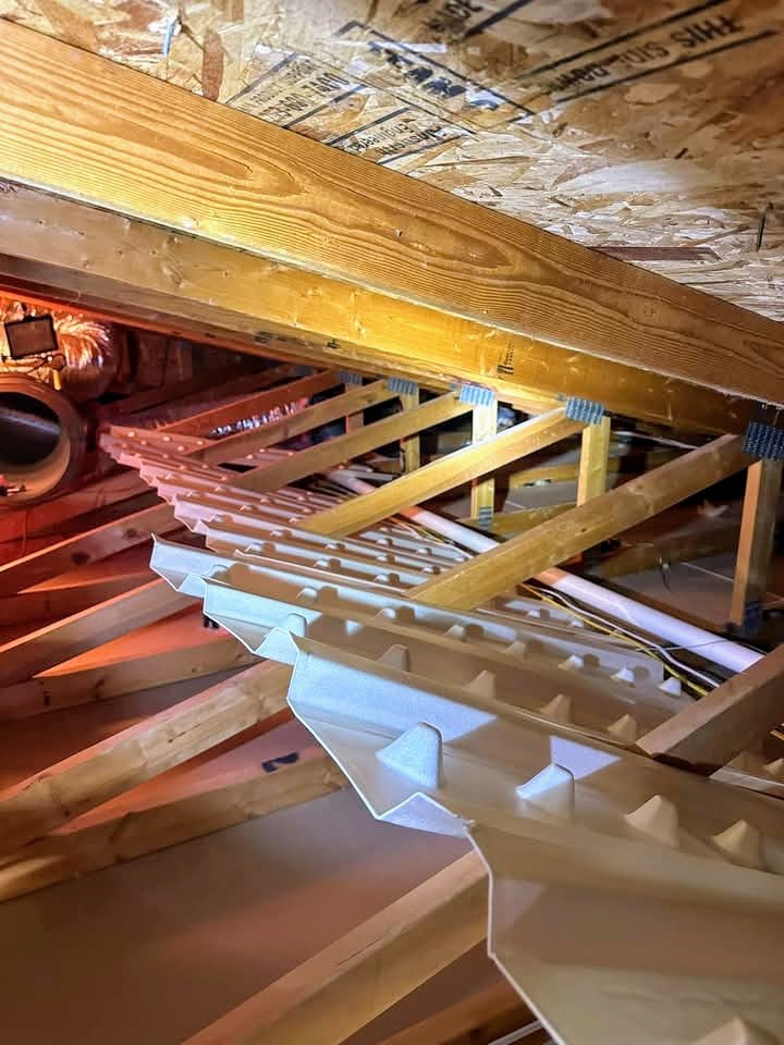 Close-up view of wooden trusses and insulation in an attic space