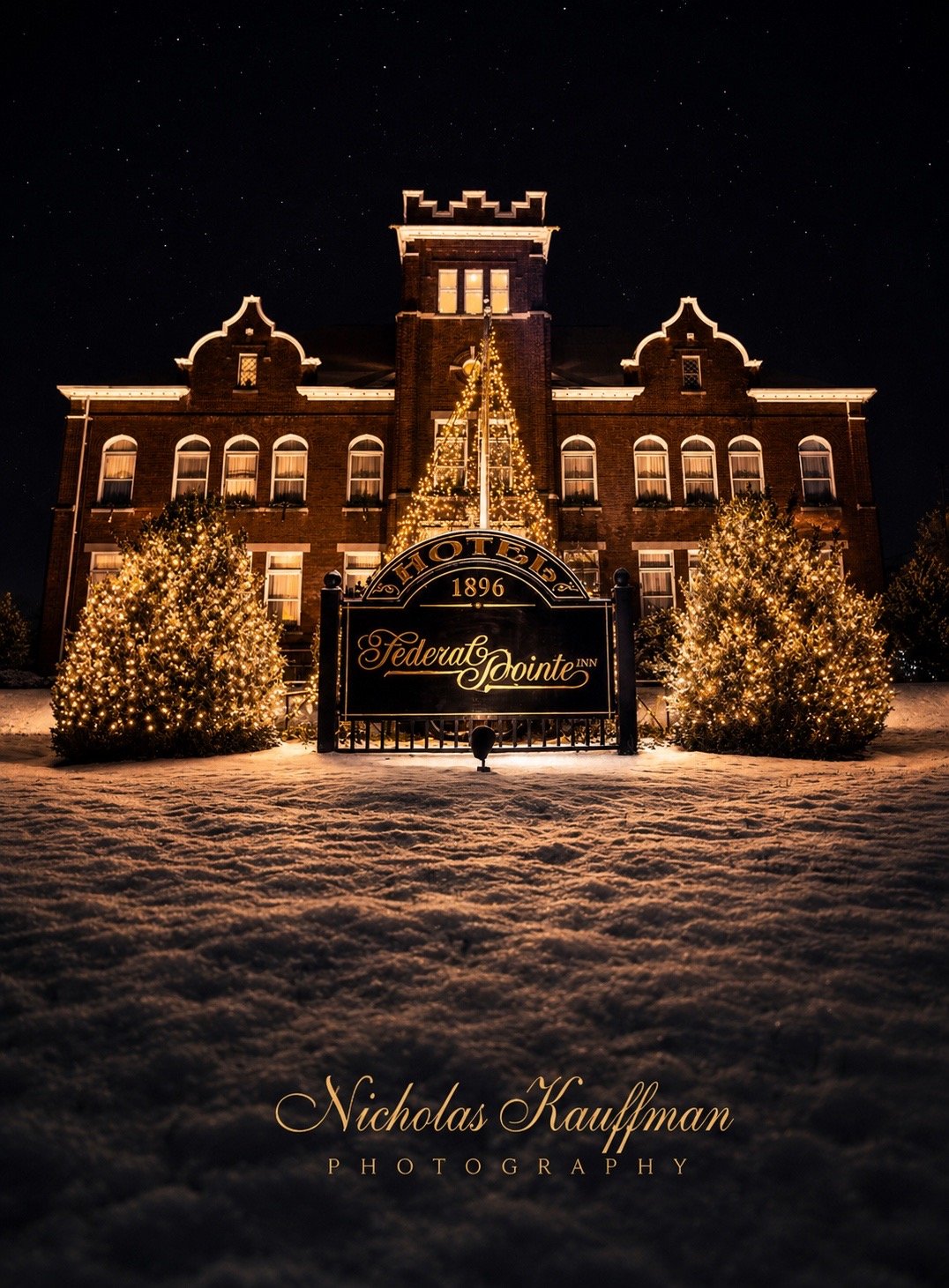 Federal Pointe Inn entrance with Christmas tree and snow at night