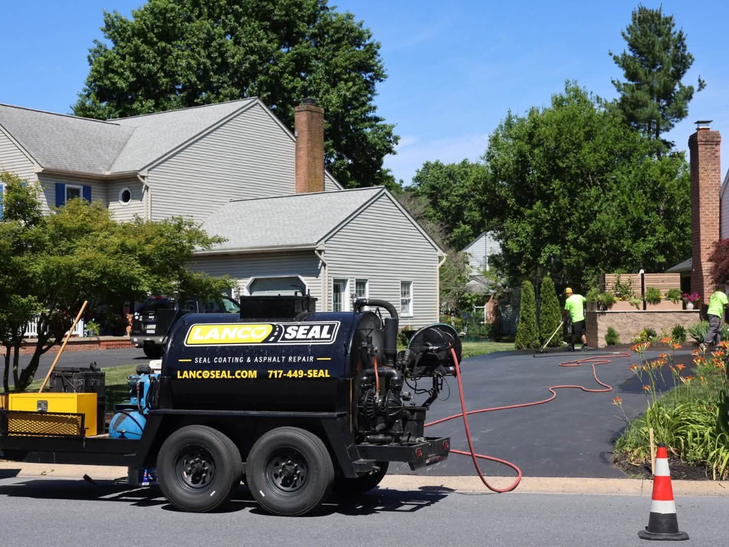 Lanco Seal asphalt repair truck parked on a street with workers in the background