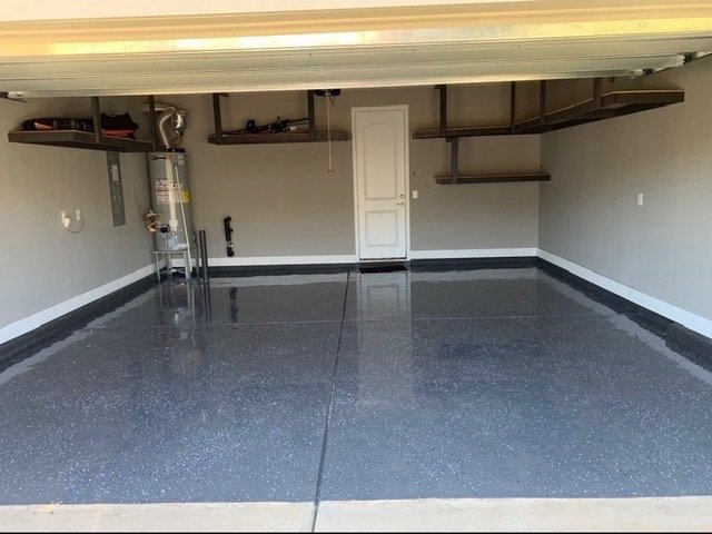 An empty garage with a polished concrete floor and shelves on the wall