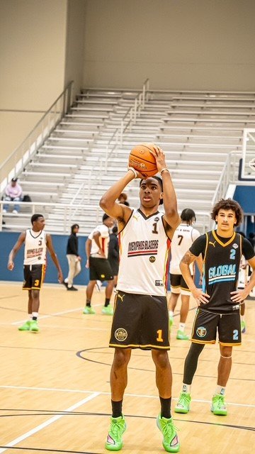Terry Smith Jr. holding a basketball on a basketball court with teammates