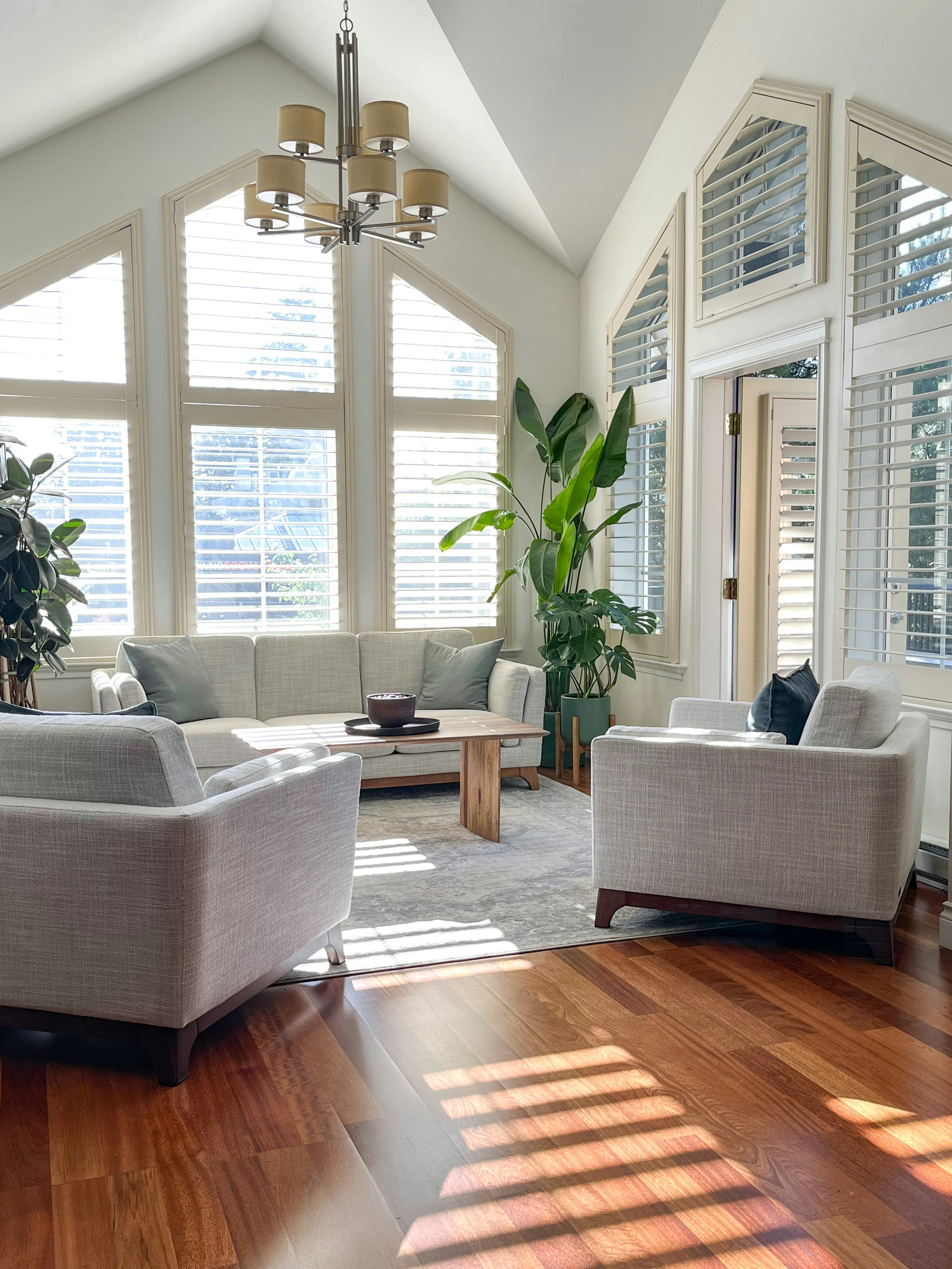A modern living room with wooden floors, a beige sofa, and a wooden coffee table