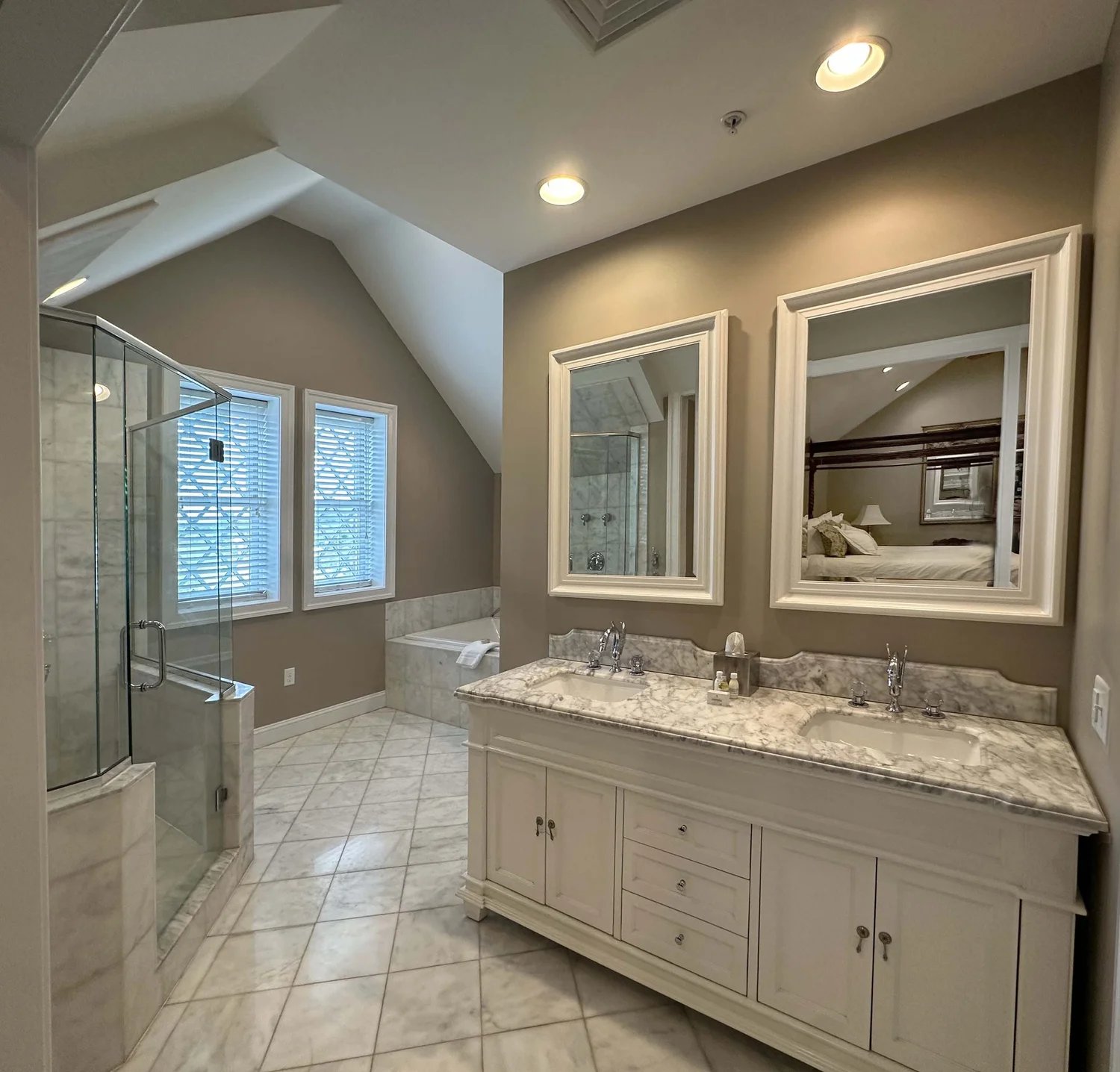 A luxurious master bathroom with a double vanity, a glass shower, and a bathtub, reflecting a modern and elegant design.