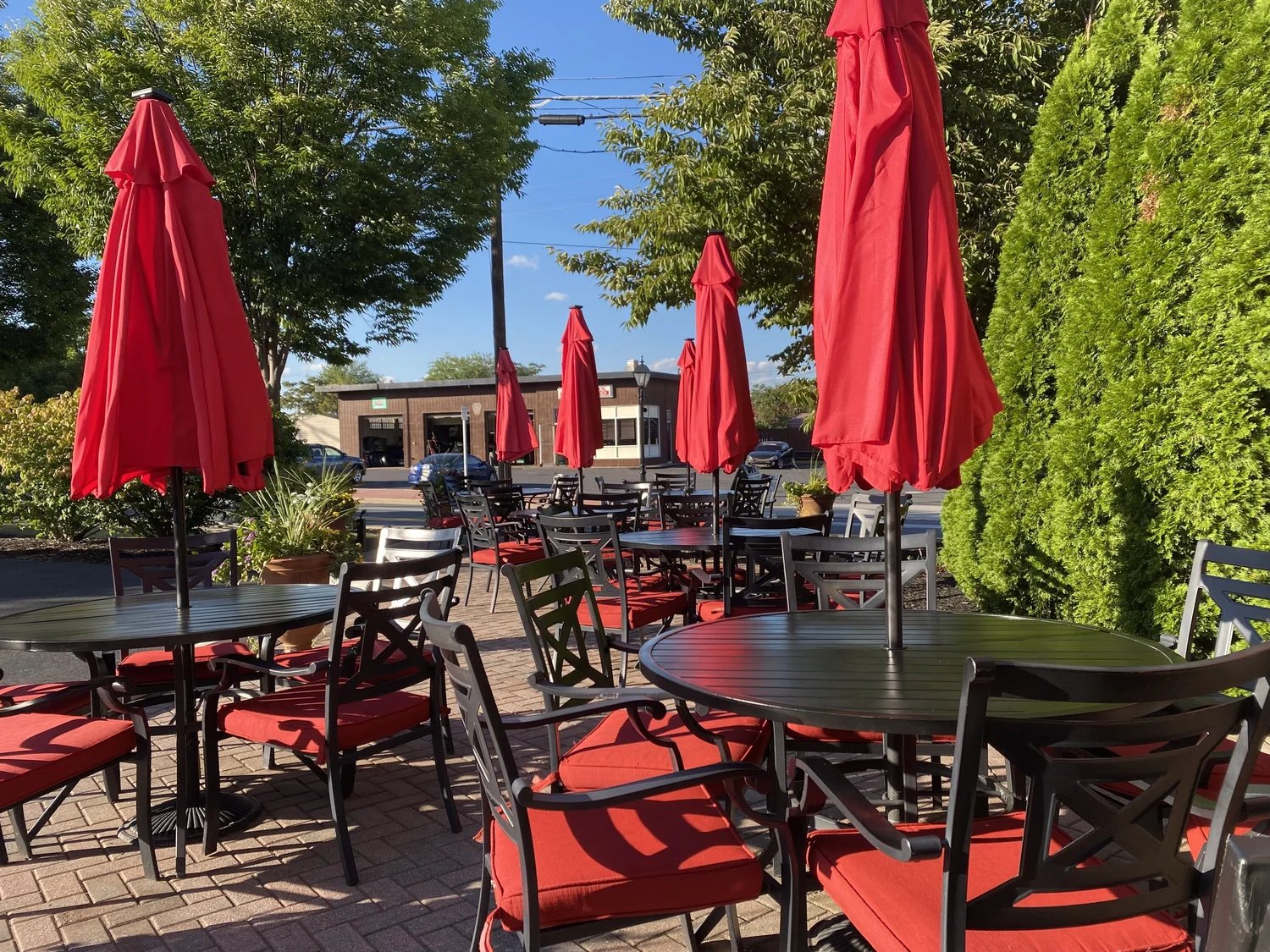 Outdoor dining area with red umbrellas and chairs at a restaurant