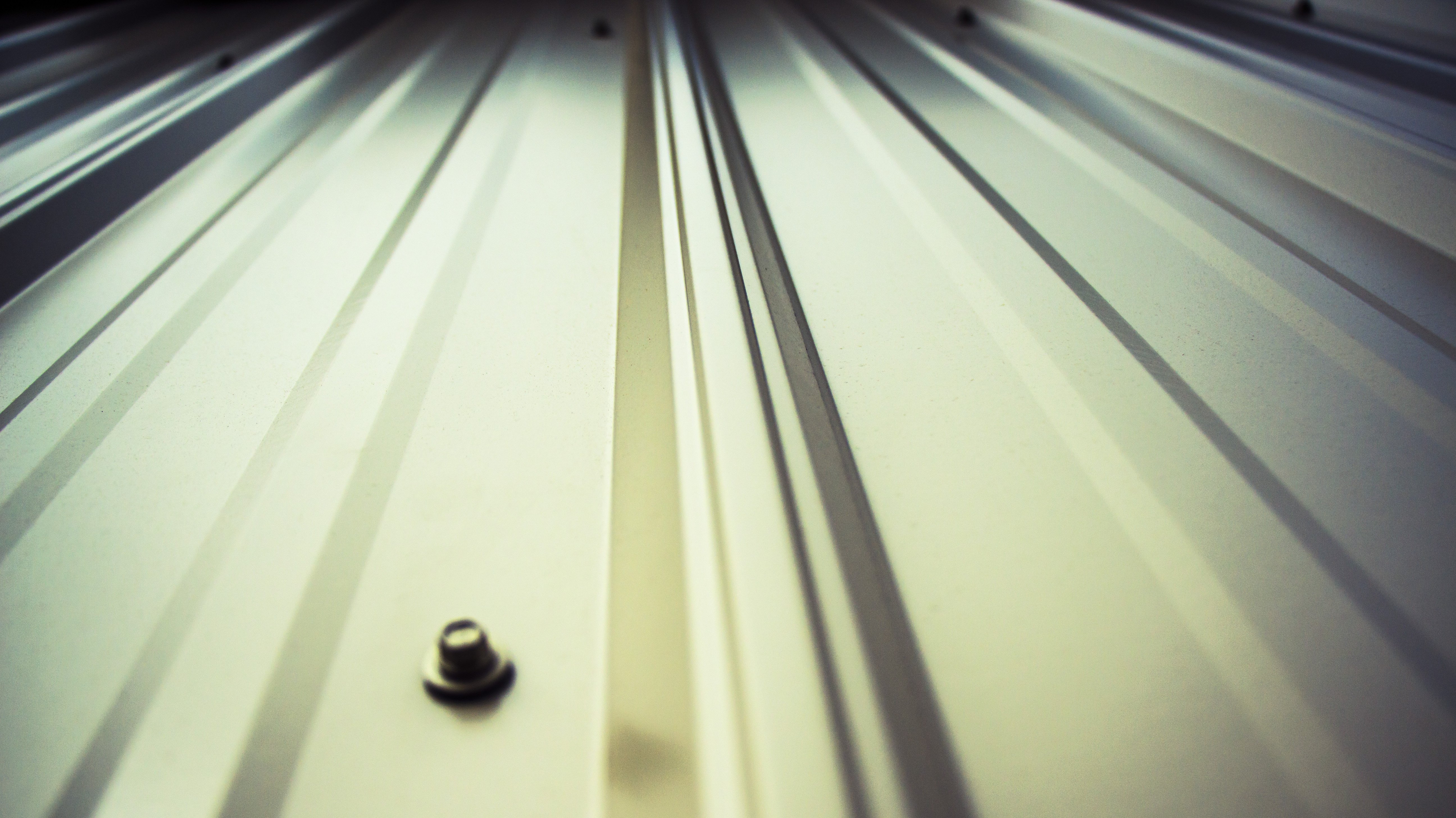 Close-up of a metal panel with a small screw in the center