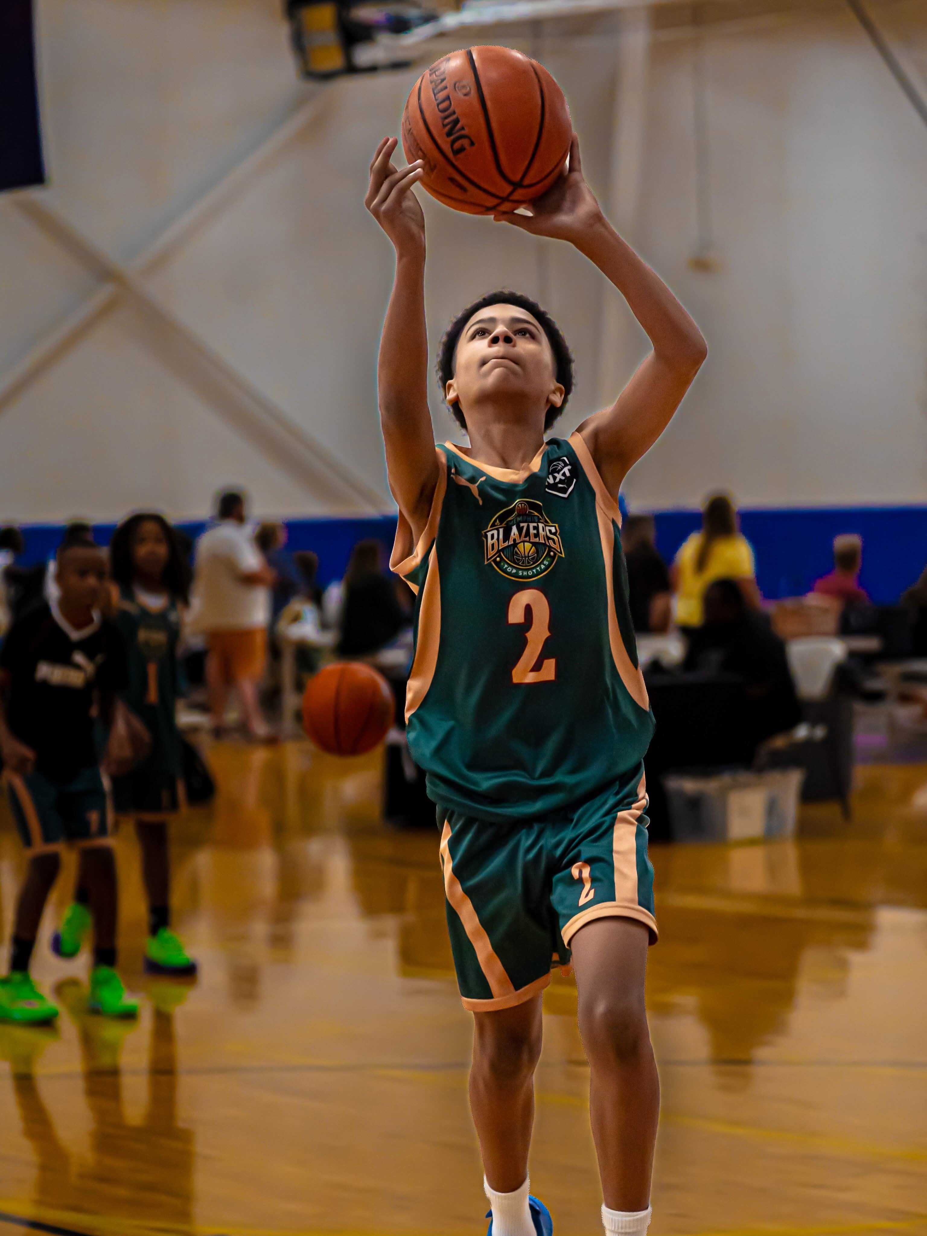 13U basketball player C.J. shooting a basketball in a green jersey