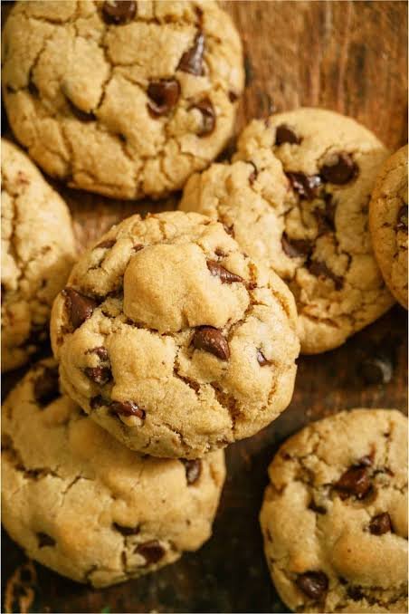 Close-up of freshly baked chocolate chip cookies on a wooden surface
