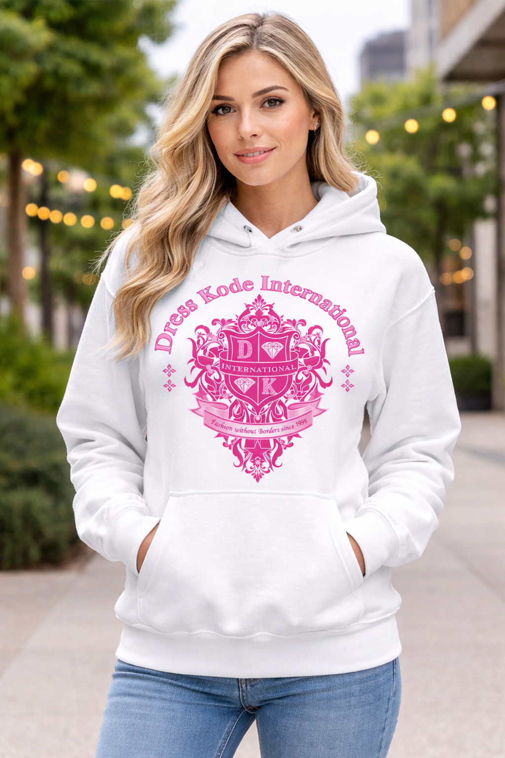 A woman wearing a white hoodie with a pink logo that says Dress Kode International