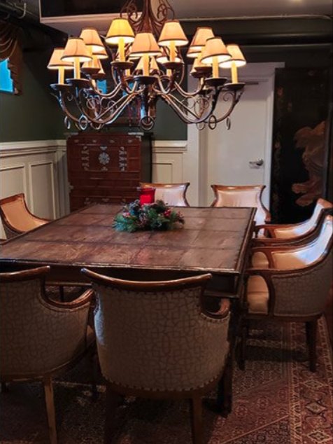 A luxurious dining room with a large wooden table, elegant chairs, and a chandelier