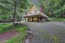 A cabin surrounded by greenery near Paupackan Lake