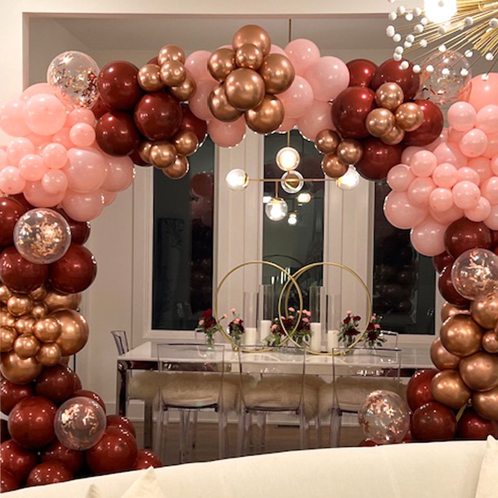 A dining area decorated with a balloon arch for a festive event