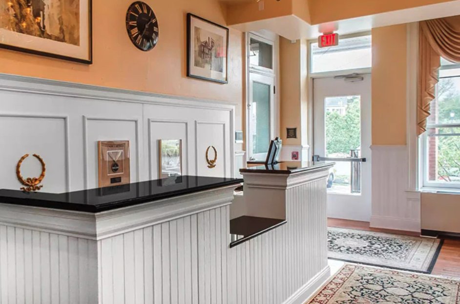 Reception area with a white desk, black countertop, and framed pictures on the wall