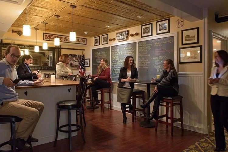 A group of people sitting at a bar counter in a cozy restaurant.