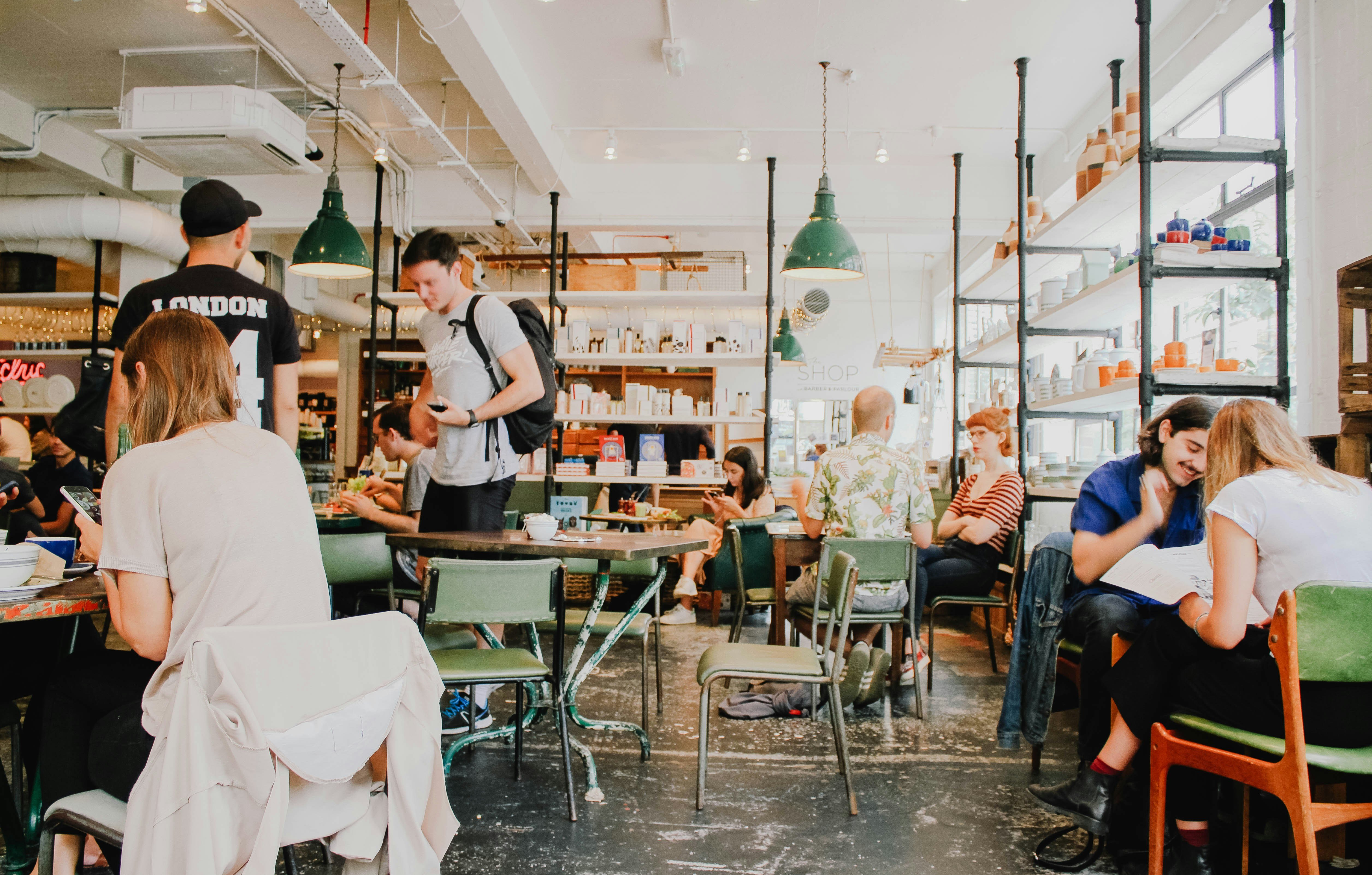 A group of people sitting at tables in a cafe with a modern industrial design